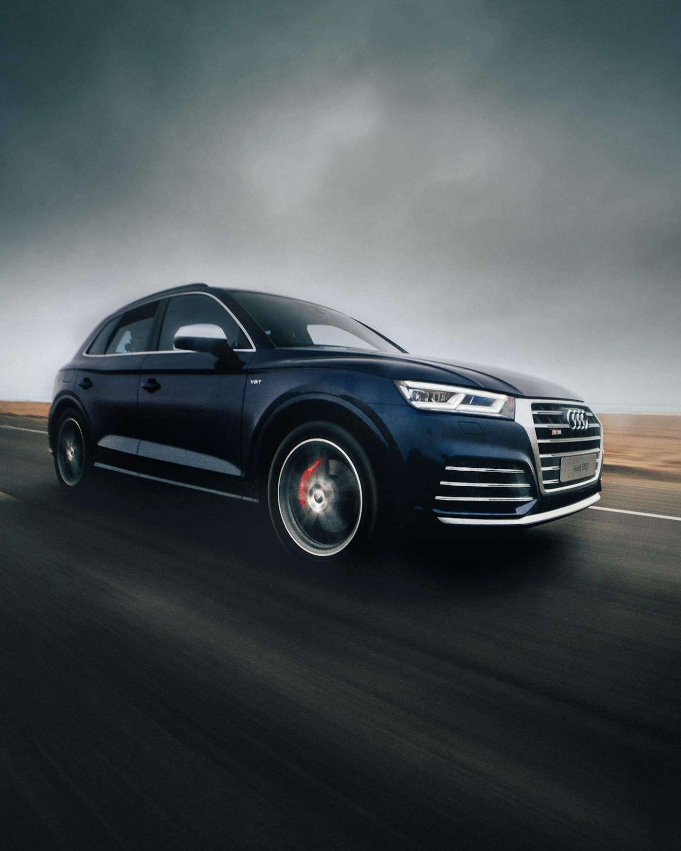 Dark blue Audi Q5 driving on an open road