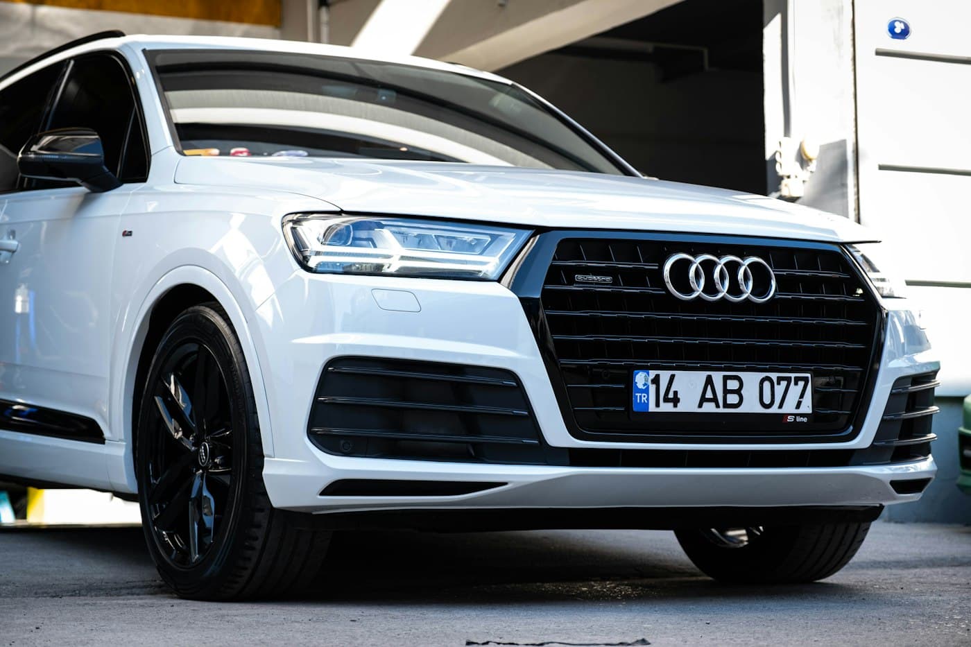 White Audi Q7 parked in front of a building