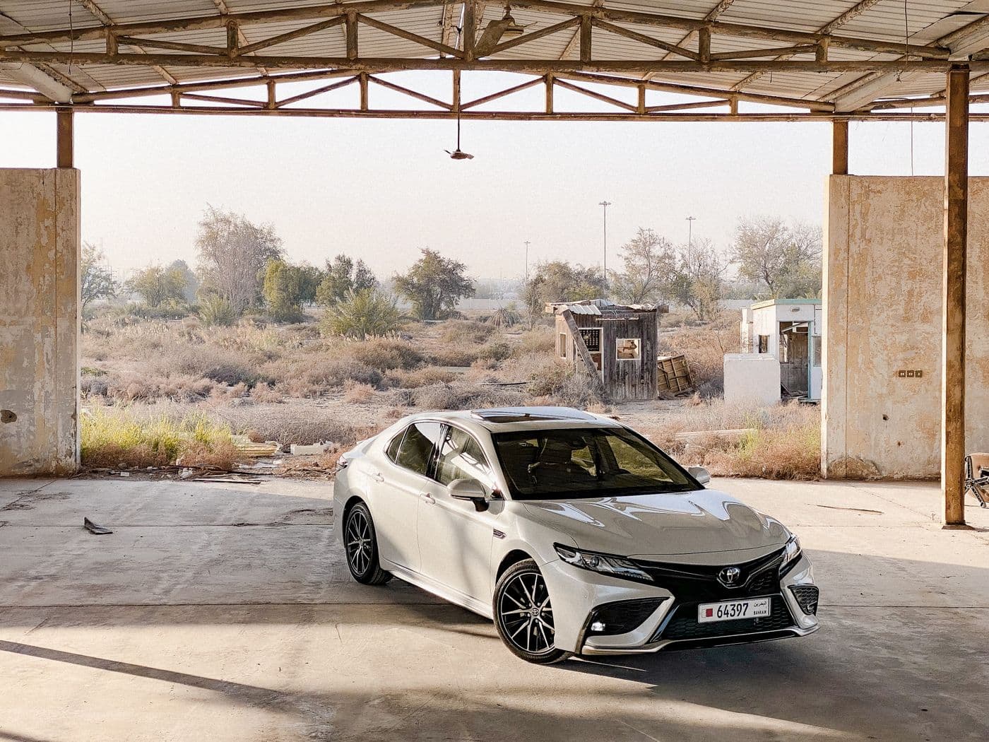 White Toyota Camry under an industrial canopy